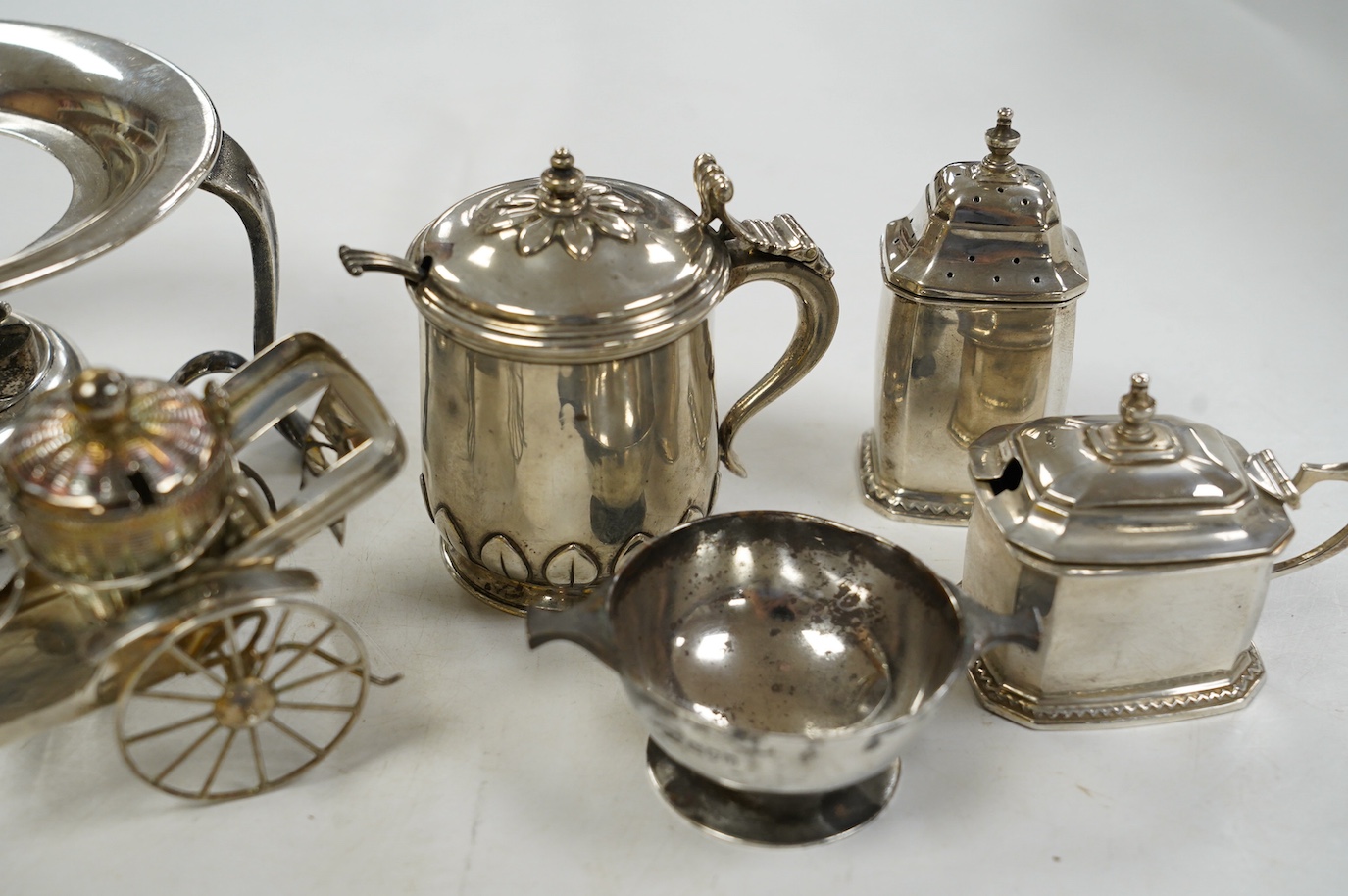 Five assorted silver condiments, including Chinese white metal modelled a rickshaw, together with a plated tea kettle stand with burner. Condition - poor to fair
